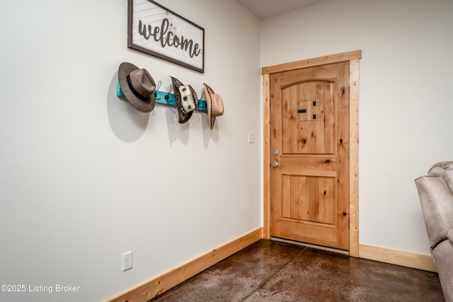 doorway with finished concrete flooring and baseboards