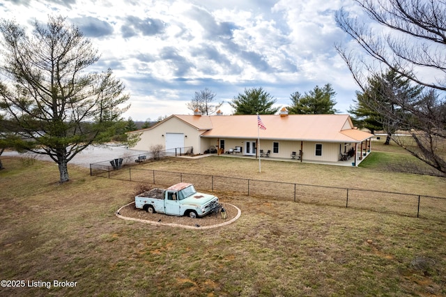 view of front of house with a garage, a front lawn, and a fenced backyard