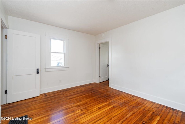 empty room featuring baseboards and hardwood / wood-style floors