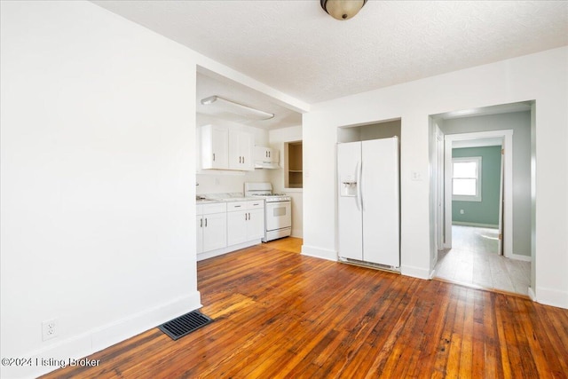 kitchen featuring a textured ceiling, white appliances, visible vents, white cabinetry, and wood-type flooring