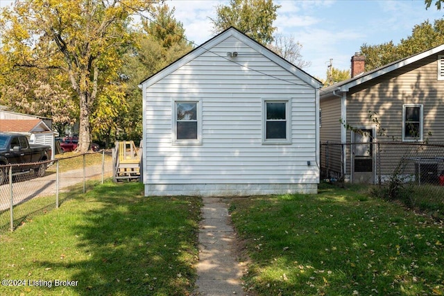 view of property exterior featuring fence and a lawn