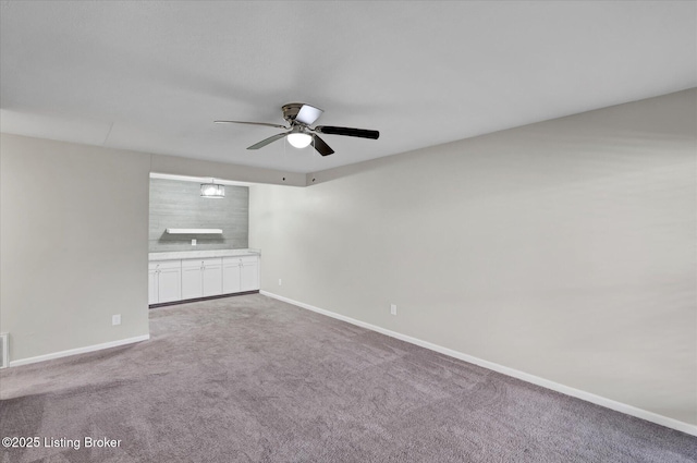 spare room featuring baseboards, carpet floors, and ceiling fan