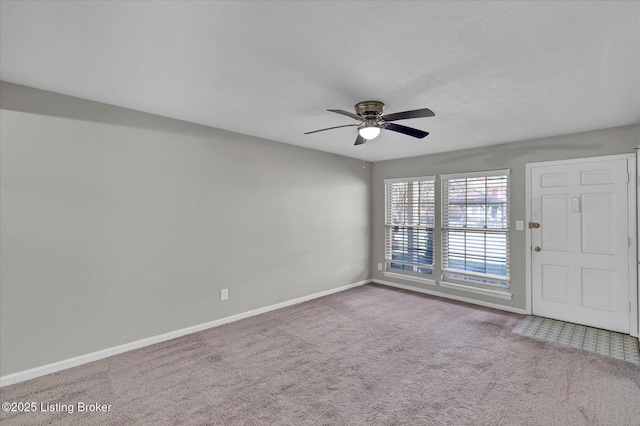 spare room with baseboards, carpet floors, and ceiling fan