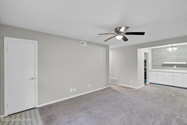 unfurnished living room with visible vents, carpet flooring, baseboards, and ceiling fan