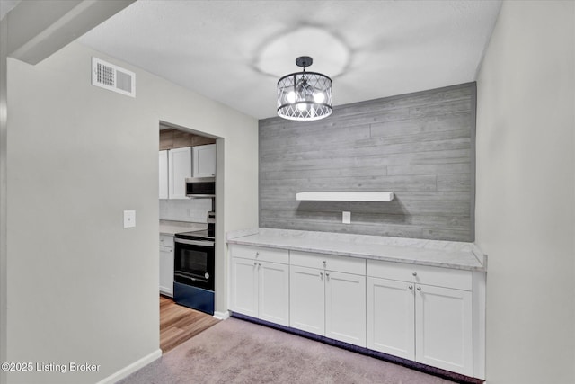 kitchen with white cabinetry, stainless steel microwave, electric range, and visible vents