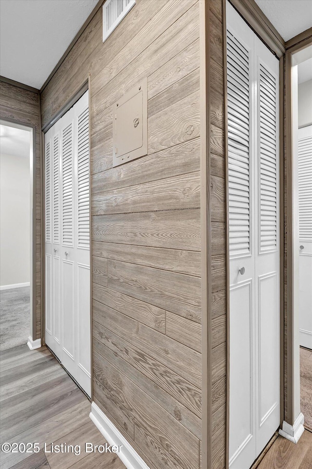 interior space with wood walls, baseboards, and wood finished floors