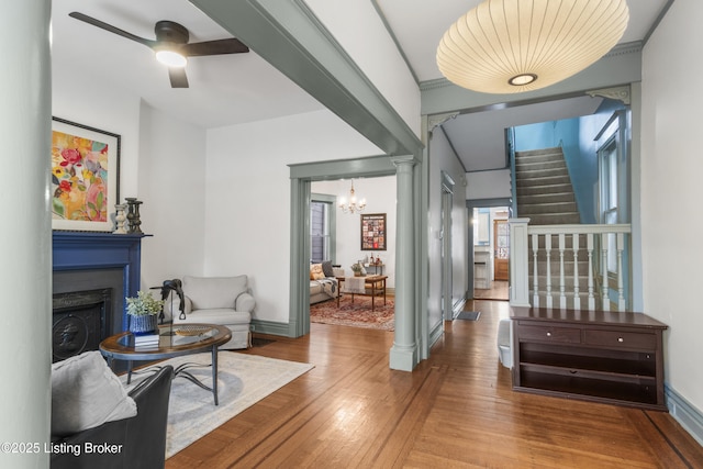 interior space with baseboards, decorative columns, a chandelier, and wood finished floors