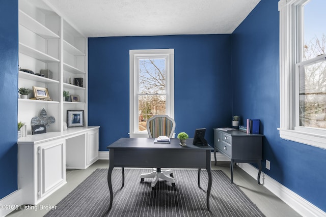 home office with baseboards and a textured ceiling