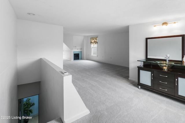 bathroom with a fireplace, a sink, and baseboards