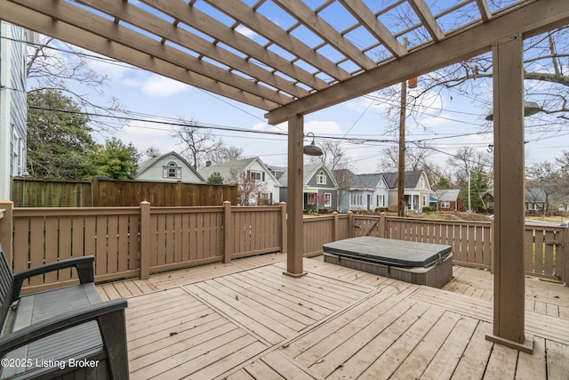 wooden terrace with a covered hot tub, a residential view, and a pergola