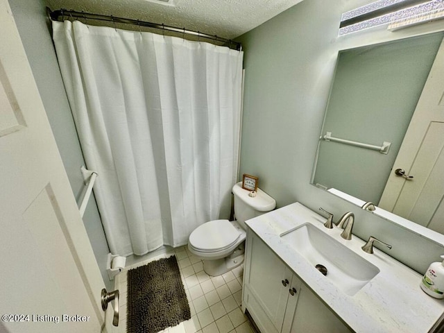 full bathroom with a textured ceiling, toilet, vanity, and tile patterned floors