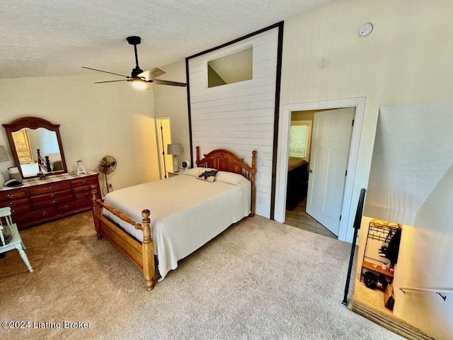 bedroom with light carpet, high vaulted ceiling, a textured ceiling, and a ceiling fan