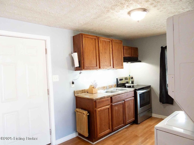 kitchen featuring electric stove, brown cabinetry, washer / dryer, and radiator