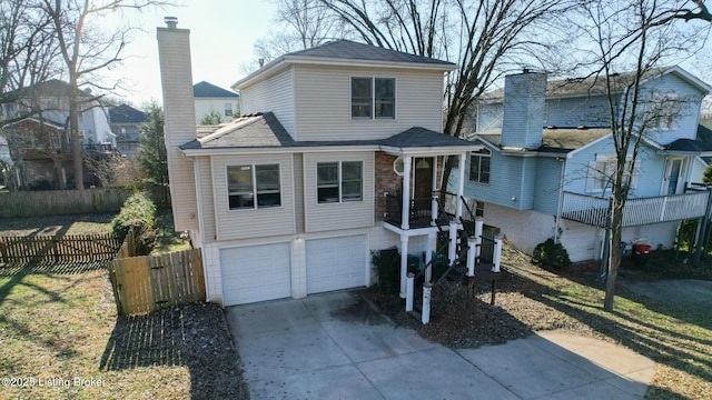 view of front of house featuring an attached garage, a chimney, fence, and concrete driveway