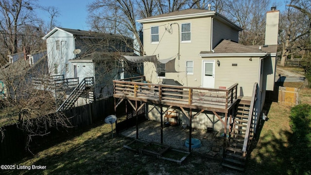 back of property featuring fence, stairway, and a deck