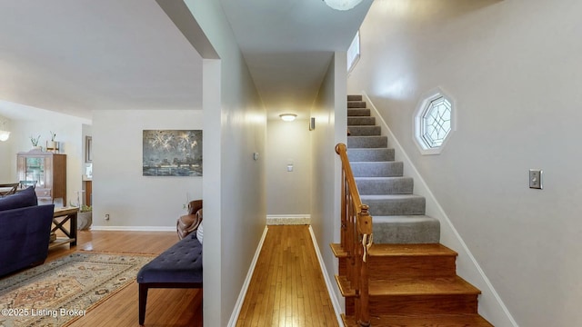 stairway with hardwood / wood-style flooring and baseboards