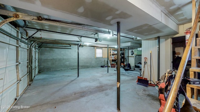 basement with a garage and concrete block wall