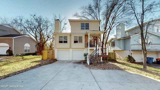 view of front facade featuring stairs, concrete driveway, a chimney, and an attached garage