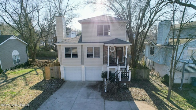 view of front facade featuring a garage, fence, driveway, a front lawn, and a chimney