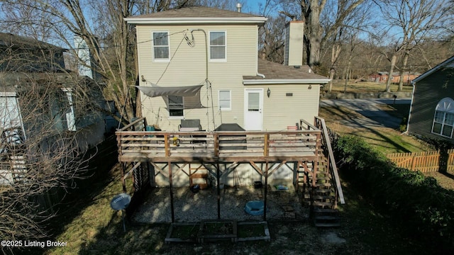 rear view of house featuring stairs, a chimney, fence, and a wooden deck