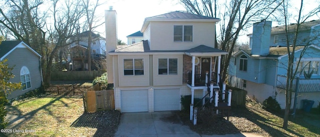 view of front of home featuring driveway, an attached garage, a chimney, and fence