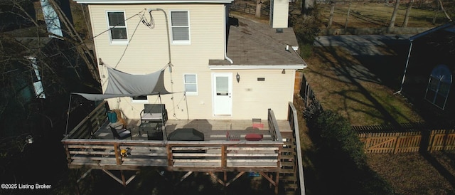 back of property with fence and a deck