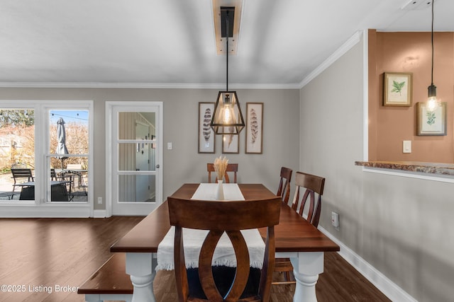 dining area with dark wood-style floors, ornamental molding, and baseboards