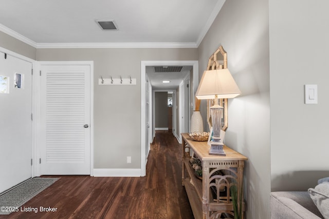 hall with ornamental molding, visible vents, dark wood finished floors, and baseboards