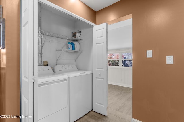 laundry room with laundry area, washing machine and clothes dryer, and baseboards