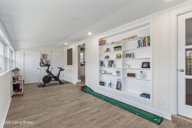 workout room with vaulted ceiling, wood finished floors, and built in features