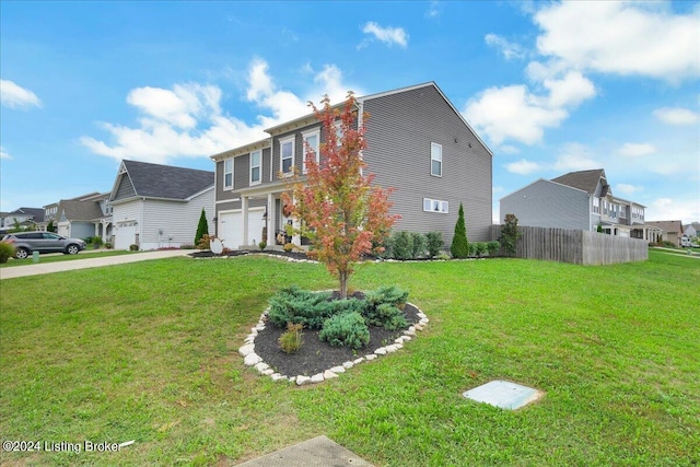 view of front of home with an attached garage, fence, driveway, a residential view, and a front lawn