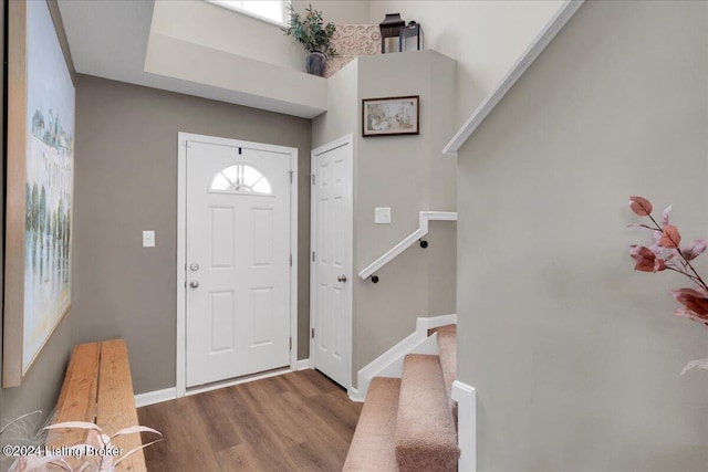 foyer with stairway, wood finished floors, and baseboards