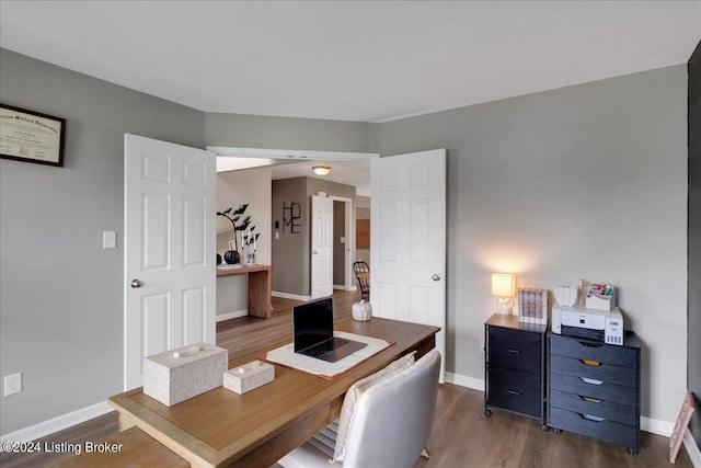 office area with dark wood-style flooring and baseboards