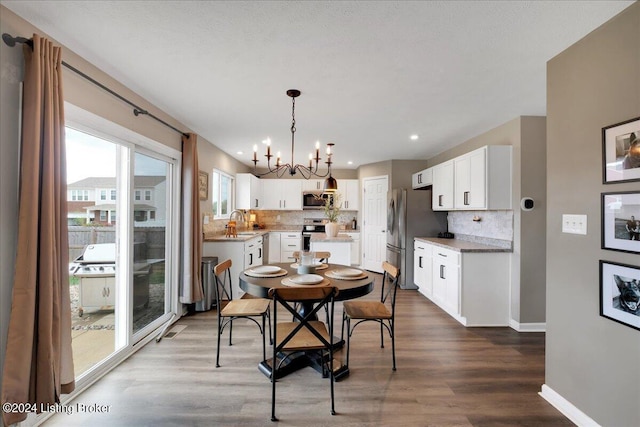 dining area with baseboards, dark wood finished floors, a notable chandelier, and recessed lighting