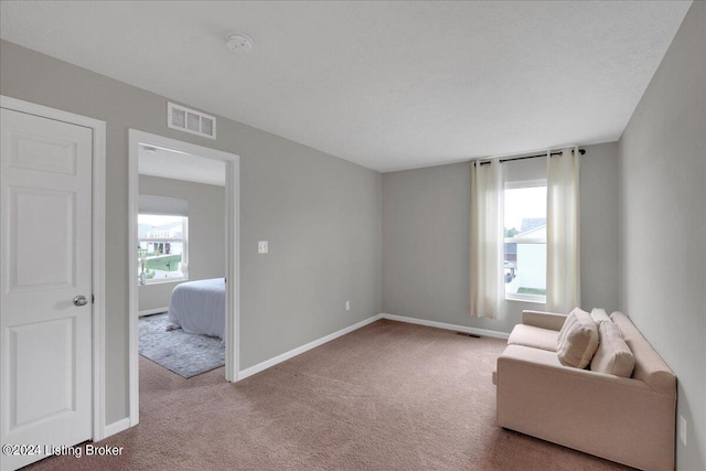 sitting room with carpet, visible vents, and baseboards