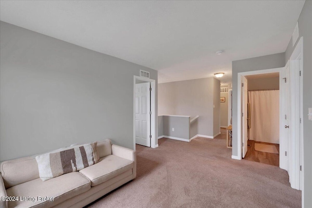 unfurnished living room featuring carpet floors, visible vents, and baseboards