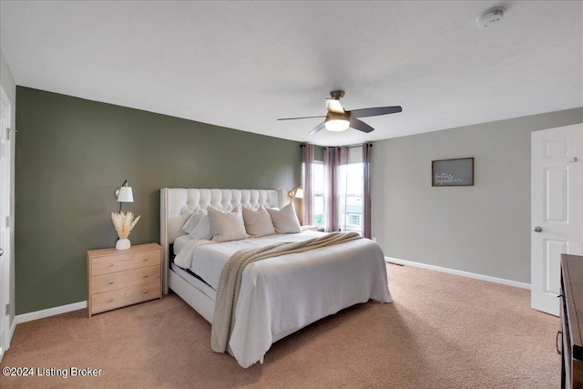 bedroom with light carpet, baseboards, and a ceiling fan