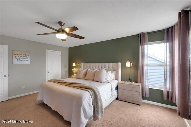 bedroom featuring light carpet, ceiling fan, and baseboards