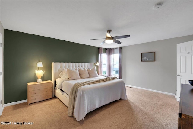 bedroom with baseboards, a ceiling fan, and light colored carpet