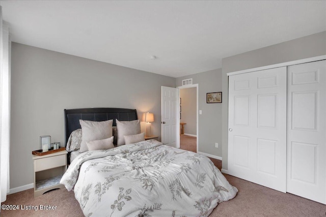 carpeted bedroom featuring a closet, visible vents, and baseboards