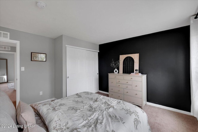 bedroom featuring light carpet, a closet, visible vents, and baseboards