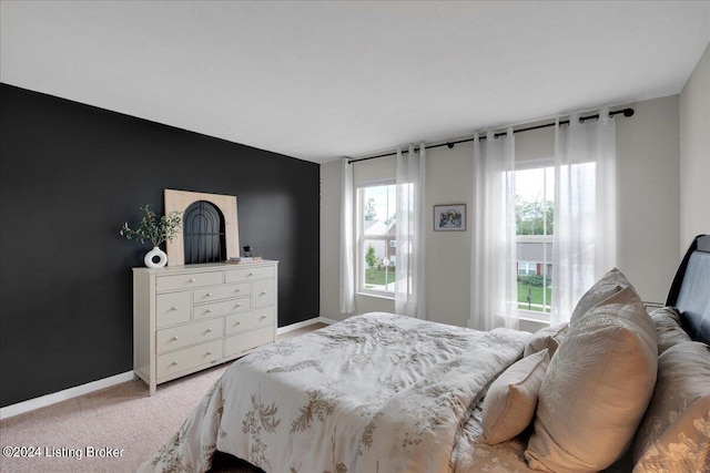 bedroom featuring light colored carpet and baseboards