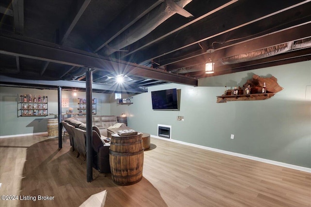 finished basement featuring a fireplace, baseboards, and wood finished floors