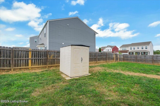 view of yard with a fenced backyard, a storage unit, and an outdoor structure