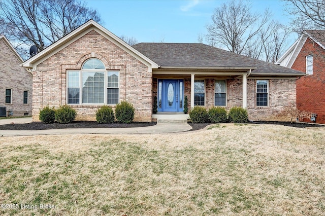 single story home with a shingled roof, a front yard, central AC, and brick siding