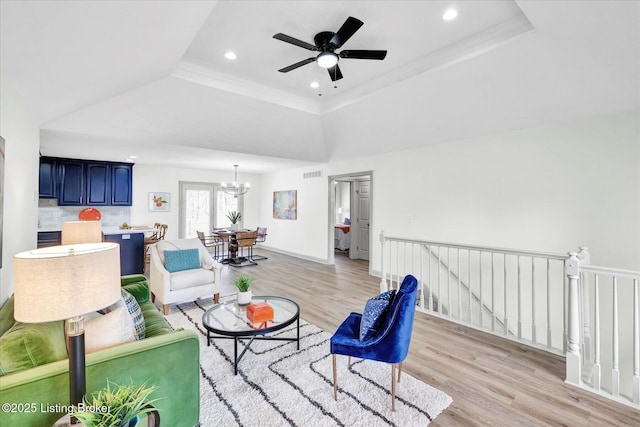 sitting room featuring visible vents, a raised ceiling, an upstairs landing, light wood-style floors, and recessed lighting