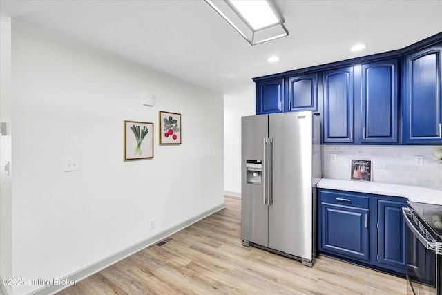 kitchen with stainless steel appliances, light wood-style floors, decorative backsplash, and blue cabinetry