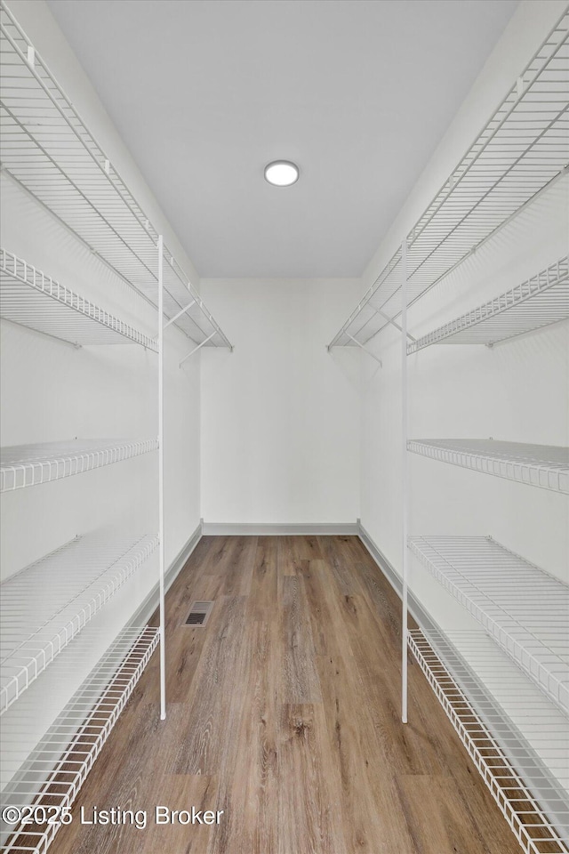 walk in closet featuring wood finished floors and visible vents