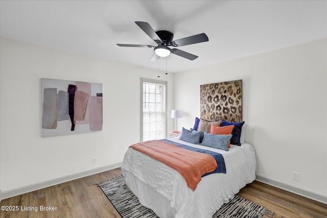 bedroom featuring wood finished floors, a ceiling fan, and baseboards