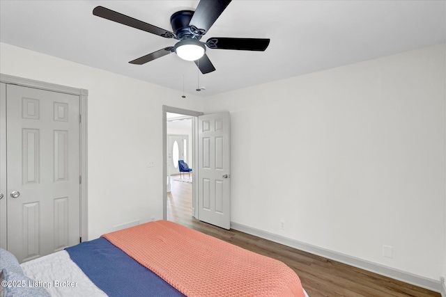 bedroom featuring visible vents, baseboards, ceiling fan, and wood finished floors